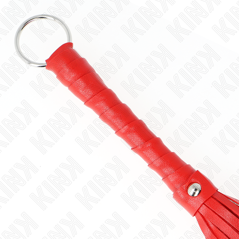 Gros plan du manche rouge enroule et de l'anneau metallique du mini martinet. Detail de la prise et de la finition de cet accessoire de spanking debutant.