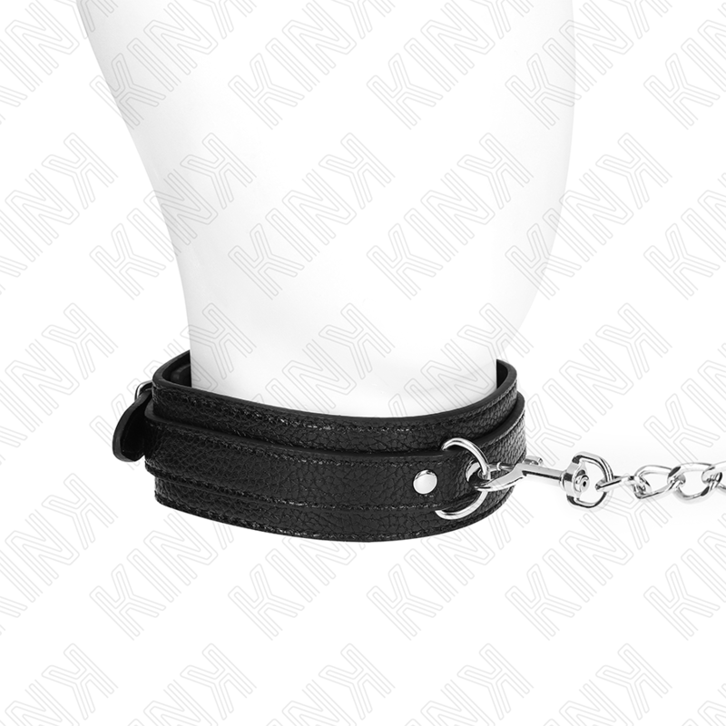 Collier de soumission en cuir noir porté au cou d'un mannequin, relié à une laisse en chaîne argentée, accessoire de jeu dominant-soumis.