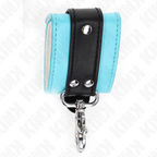 Detail d'une manchette de poignet en cuir noir et bleu turquoise avec son mousqueton argente pendant, rivets et couture nette pour une contention sure.