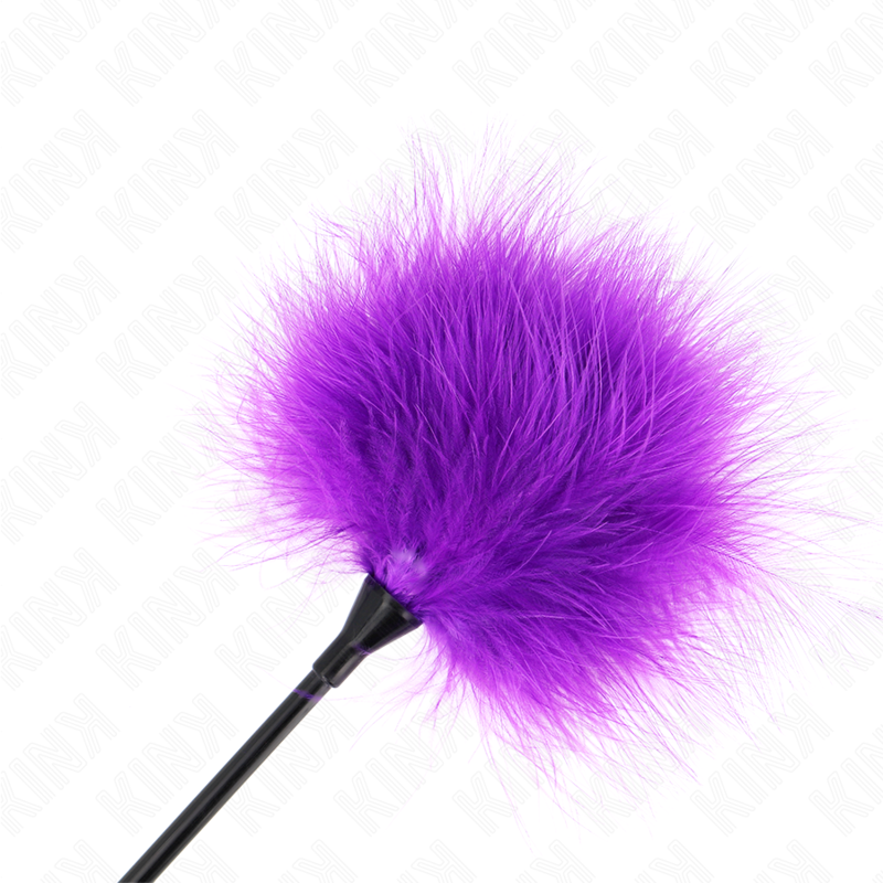 Gros plan sur le pompon de plumes violettes duveteuses d'un plumeau de chatouilles. Texture moelleuse pensee pour des caresses ultra-douces et taquines.