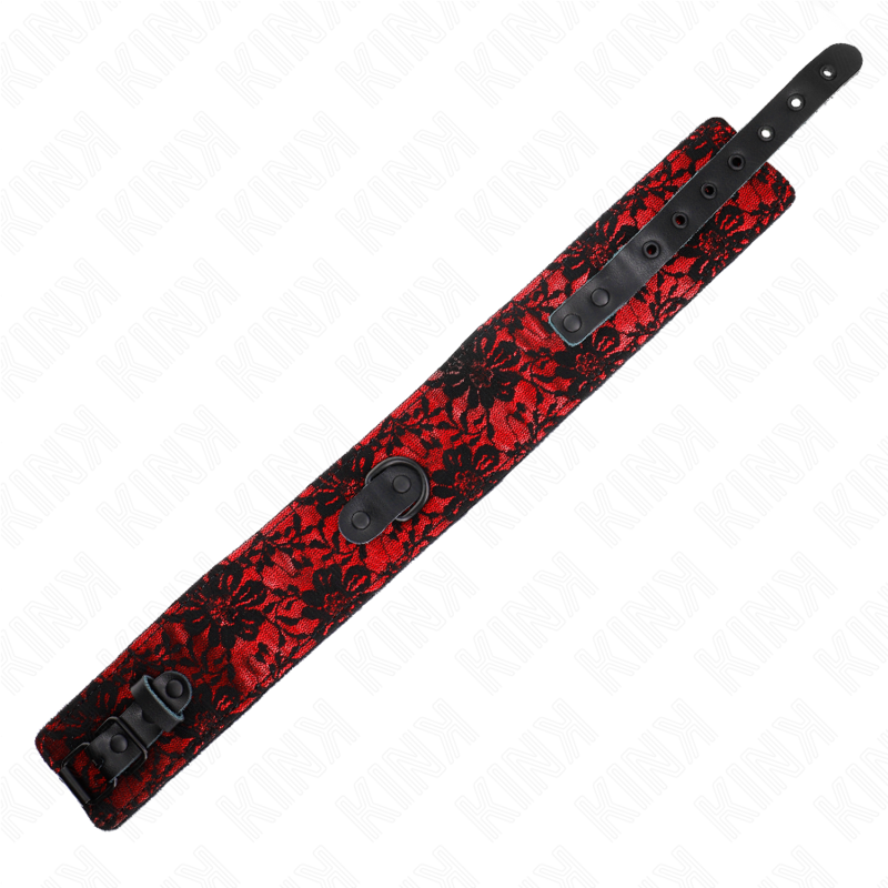 Gros plan du collier de soumission a dentelle rouge et noire deplie, sangle a boutons-pression et anneau, attache symbolique fetiche du jeu de soumission.