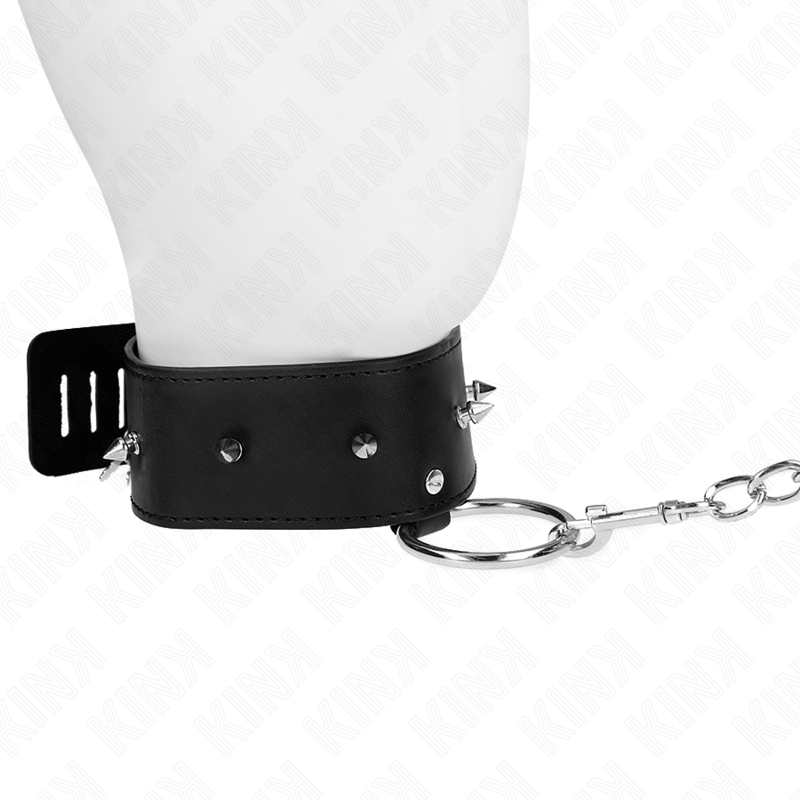 Gros plan du collier de soumission noir à pointes sur buste mannequin, courte chaîne argentée de côté. Accessoire BDSM rock au maintien marqué.
