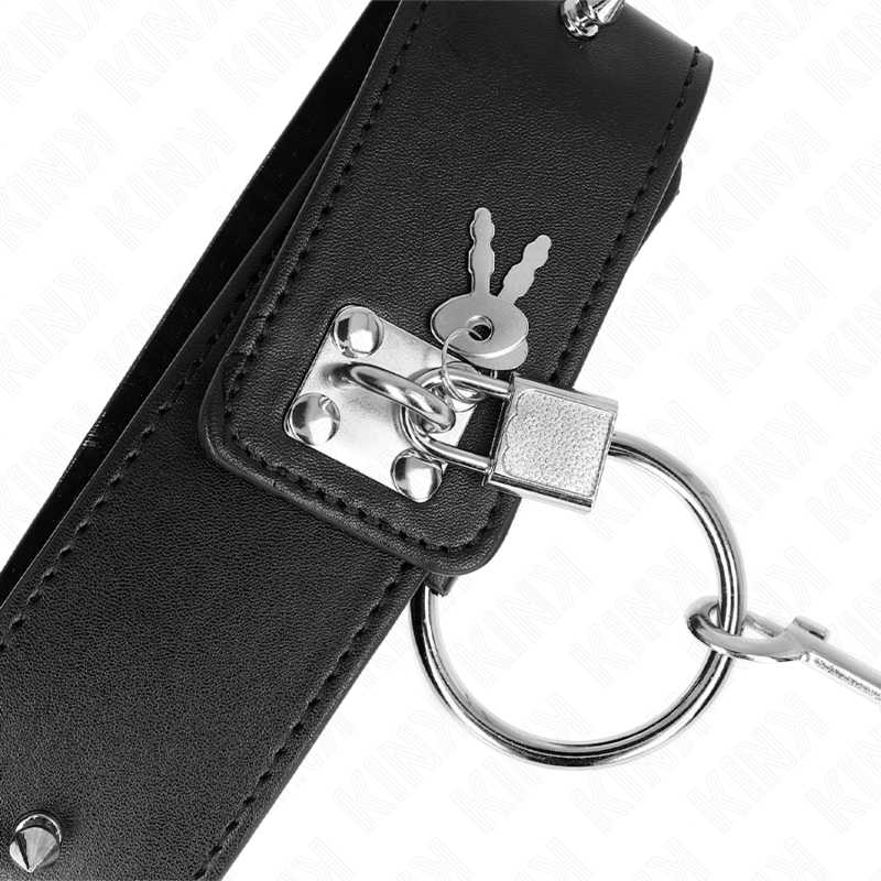 Gros plan d'un collier BDSM noir avec cadenas argenté, clés et anneau de verrouillage. Détail de la fermeture sécurisée du collier de soumission.
