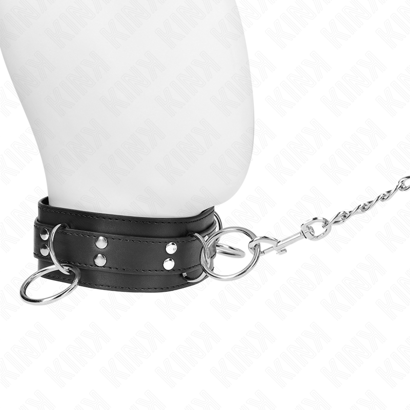 Gros plan du collier de soumission noir sur buste mannequin, chaîne argentée tendue de côté. Accessoire BDSM cuir au maintien net pour le cou.