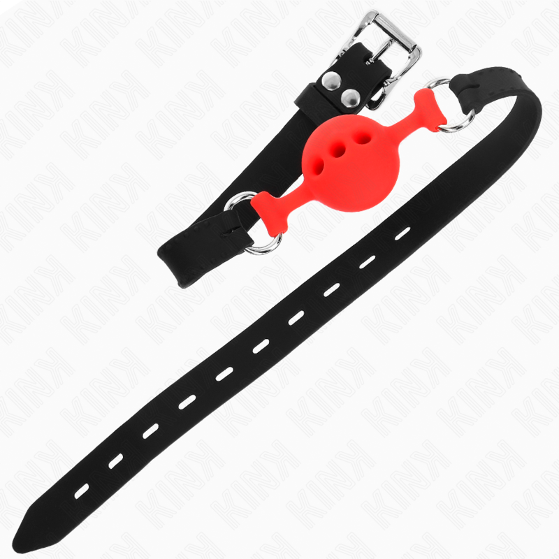 Bâillon boule rouge creuse en silicone sur sa longue sangle perforée étalée à plat, accessoire BDSM respirant pour jeux de domination en douceur.