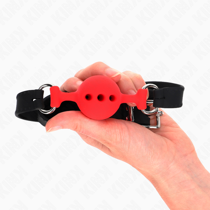 Bâillon boule rouge creuse en silicone tenu au creux de la main, échelle visible, accessoire BDSM respirant de 4 cm pour la réduction au silence.