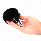 Plug anal en acier inoxydable à queue de lapin pompon noire présenté dans une main, accessoire bijou animal lisse pour le jeu de rôle coquin.