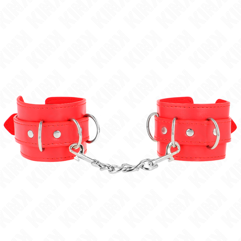 Paire de manchettes de poignets en cuir rouge a anneaux en D, reliees par une chaine argentee, posees a plat sur fond blanc, entrave de bondage coloree.