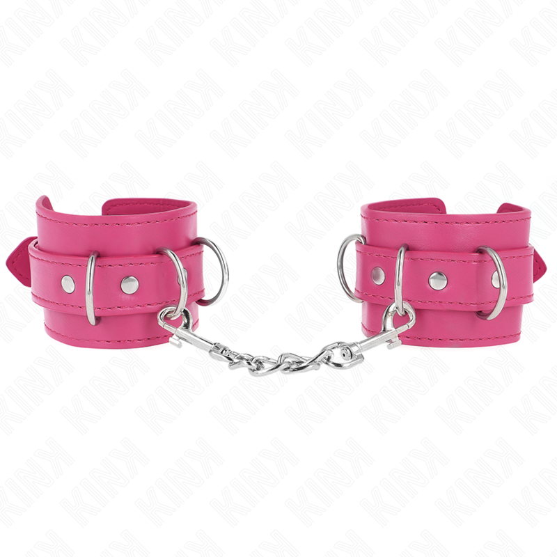 Paire de manchettes de poignets en cuir rose a anneaux en D, reliees par une chaine argentee torsadee, vue a plat, entrave de contention coloree.