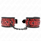 Paire de manchettes de poignets noires a motif diamant rouge reliees par chaine noire, posees sur fond blanc, accessoire de soumission au style audacieux.