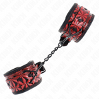 Manchettes de poignets a motif facette rouge et noir avec chaine et mousqueton noir, vue rapprochee de la texture graphique de cet accessoire BDSM.