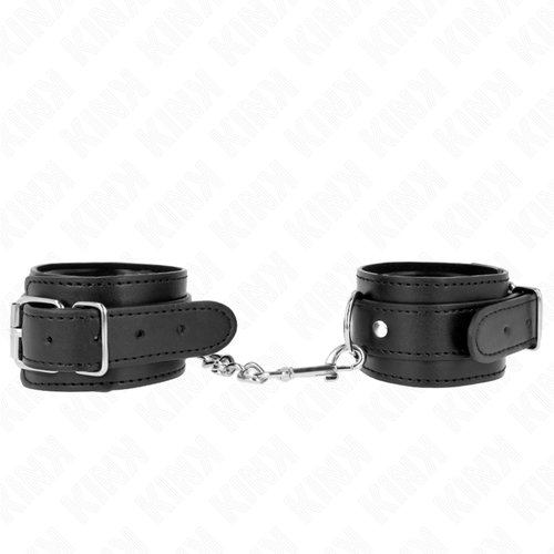 Menottes de poignets en cuir noir à boucles réglables reliées par une chaîne argentée, posées à plat, kit d'attache de contention au style donjon