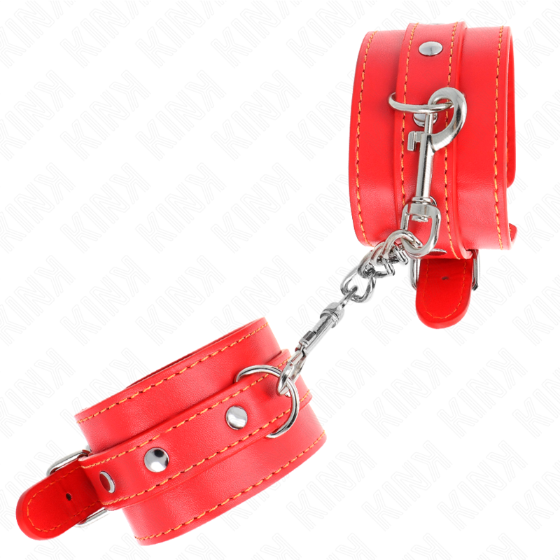 Menottes en cuir rouge cloutées reliées par une chaîne argentée présentées suspendues, kit d'attache de contention au look fétiche pour la soumission