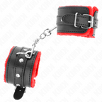 Paire de manchettes de poignets en cuir noir doublees de fourrure rouge, reliees par une chaine metallique, posees a plat avec boucle reglable pour jeux de contention BDSM.