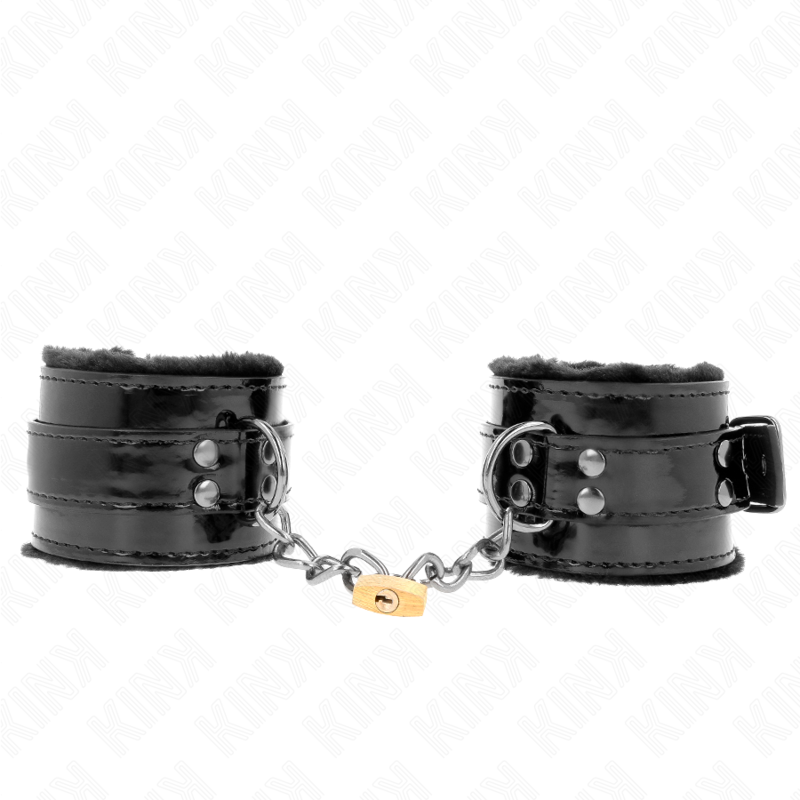 Paire de manchettes de poignets en cuir verni noir doublees de fourrure, reliees par chaine et cadenas, posees sur fond blanc, accessoire de soumission.