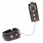 Menottes de poignets en cuir noir a surpiqures rouges et anneau en D presentees a plat avec leur chaine : contention BDSM elegante pour le jeu de domination.