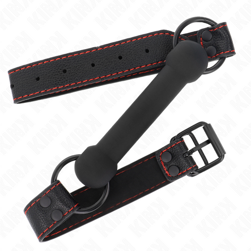Baillon mors souple silicone noir presente plie sur sa sangle cuir surpiquee rouge, barre allongee plutot que boule pour un jeu de domination feutre