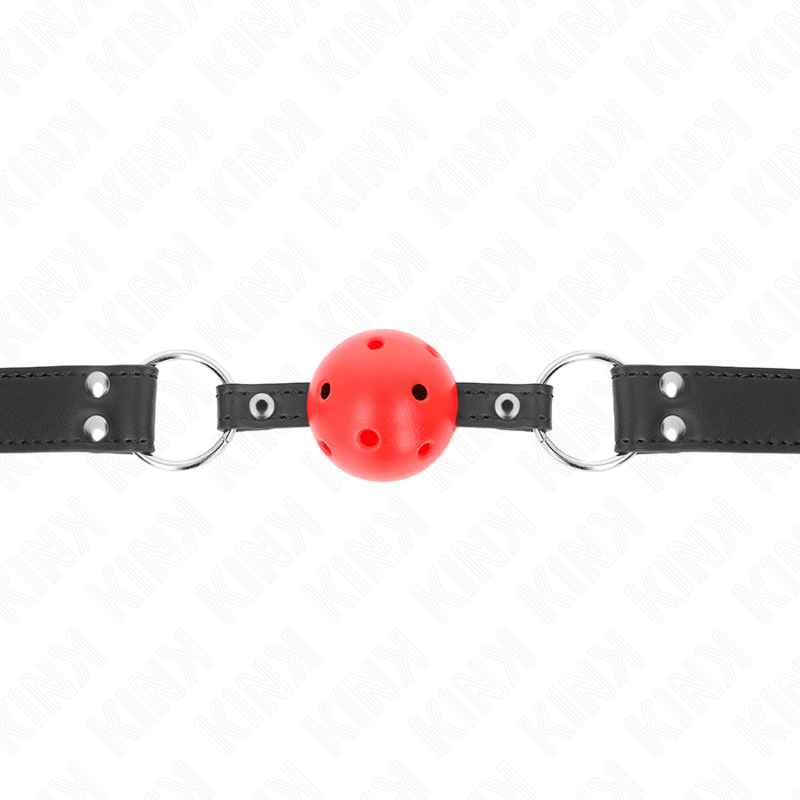 Bâillon boule rouge perforée vu de face à l'horizontale, sangle noire cloutée et anneaux métalliques de chaque côté.