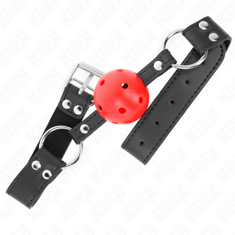 Bâillon boule rouge perforée vu en angle, boucle argentée et rivets doubles sur la sangle noire, anneaux en D aux extrémités.