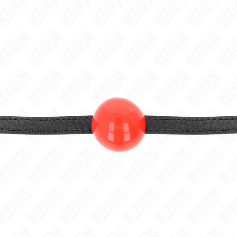 Bâillon boule rouge pleine au centre d'une lanière fine tendue, gros plan sur la boule brillante, accessoire BDSM coloré de réduction au silence.