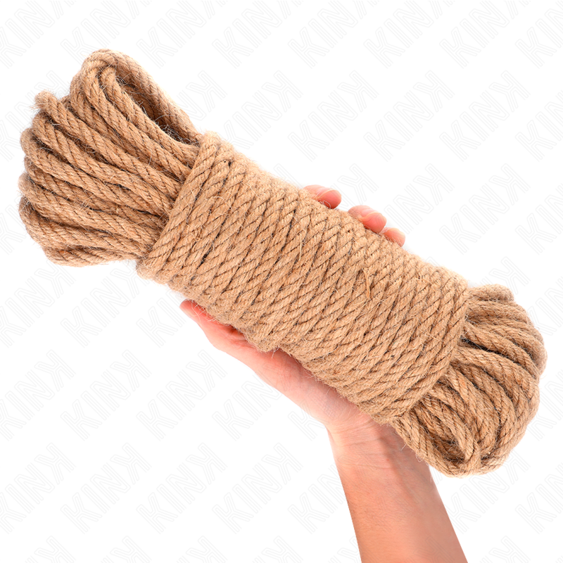 Pelote de corde de bondage en jute beige posee sur une main ouverte, fibre naturelle torsadee bien enroulee, accessoire de ligotage shibari sur fond blanc.