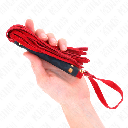 Mini martinet en daim rouge tenu en main par son manche tressé, gros plan sur les lanières souples de l'accessoire d'impact de 30 cm.