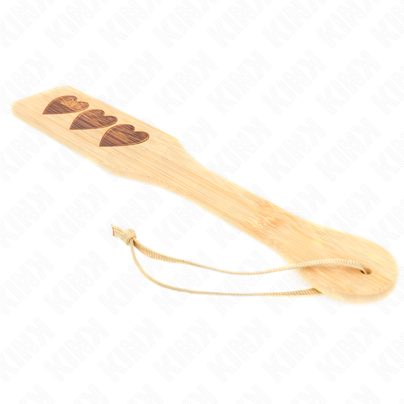 Palette de fessee en bambou a trois coeurs decoupes avec lacet de suspension, surface rigide de 32 cm pour un impact net et sonore, spanking ludique.