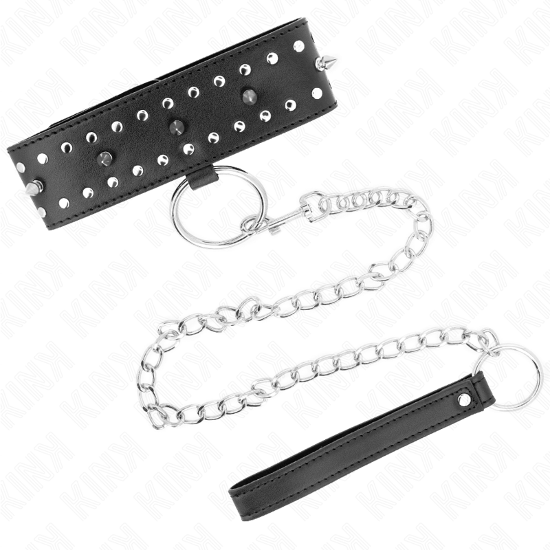 Collier de soumission noir à pointes argentées, longue chaîne et poignée cuir déployées. Kit collier-laisse BDSM au caractère affirmé.