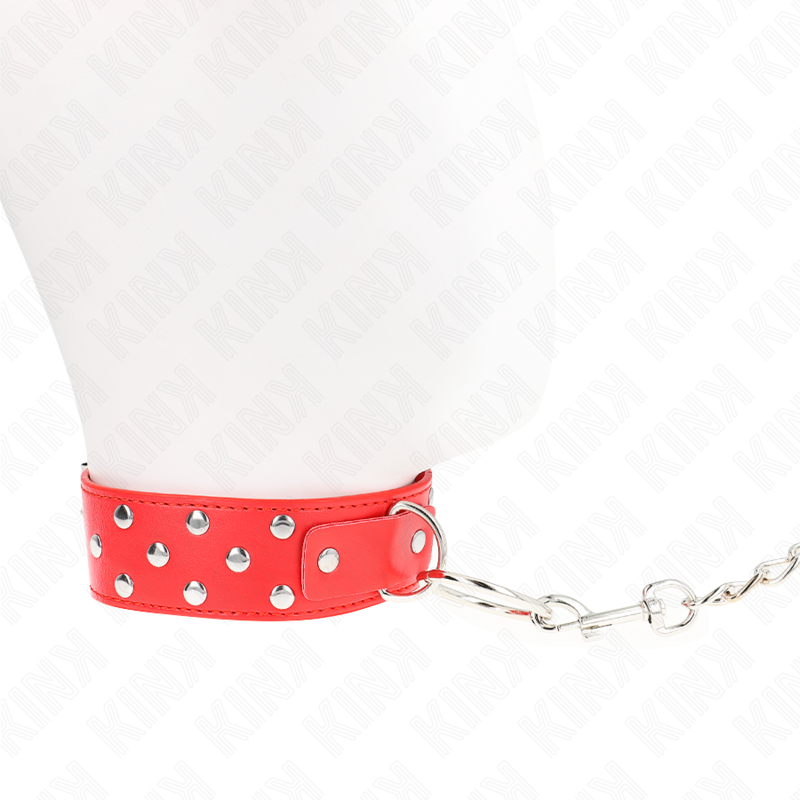 Collier de soumission rouge à rivets fermé autour du cou d'un mannequin, chaîne de laisse partant sur le côté, accessoire de domination BDSM coloré ajustable.