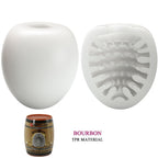 Masturbateur oeuf blanc presente ferme et en coupe revelant la texture interne nervuree en TPR, etui tonneau Bourbon pour le rangement.