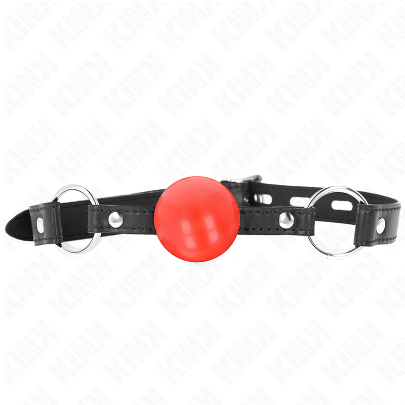 Bâillon boule rouge pleine en caoutchouc maintenu entre deux anneaux sur sangle perforée, gros plan, accessoire BDSM de domination coloré pour imposer le silence.