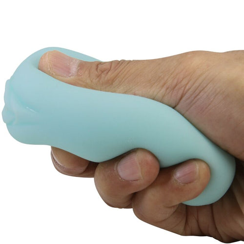 Masturbateur oeuf Catherine Masha bleu pastel pressé dans une main, coque TPR très souple et extensible illustrant la flexibilité de la matière bodysafe.