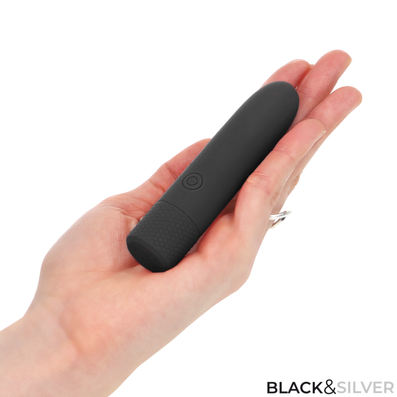 Mini vibromasseur bullet noir pose au creux de la main illustrant sa taille compacte, base texturee en silicone doux Black&Silver Geri, rechargeable et nomade