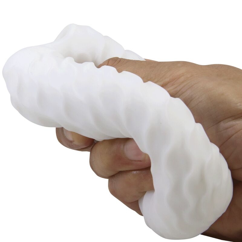 Masturbateur oeuf Fantasy Ball blanc pressé dans une main, gaine TPR à picots très souple et extensible démontrant la flexibilité de la matière bodysafe.