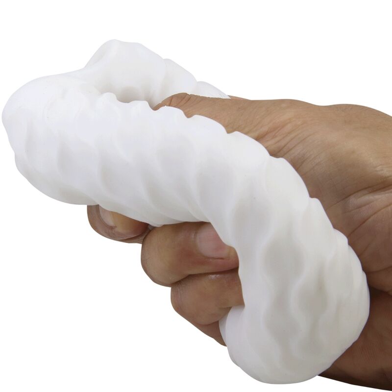 Masturbateur oeuf Fantasy Ball blanc pressé dans une main, gaine TPR à picots très souple et extensible illustrant la flexibilité de la matière bodysafe.