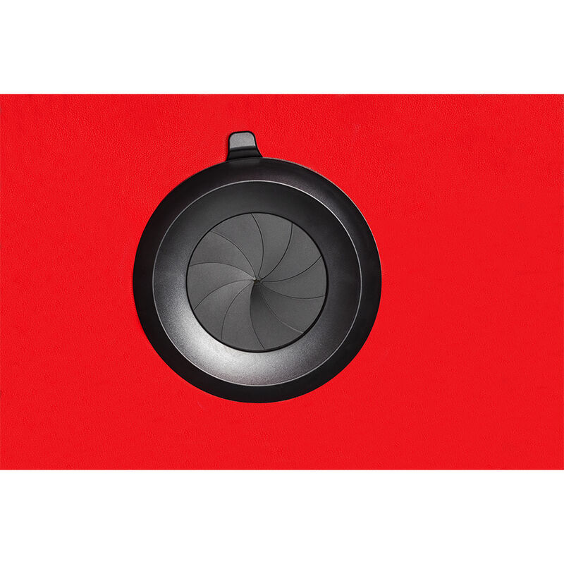 Gros plan sur le dispositif de ventilation circulaire noir a pales de la cabine Secret Dome, presente sur fond rouge brillant