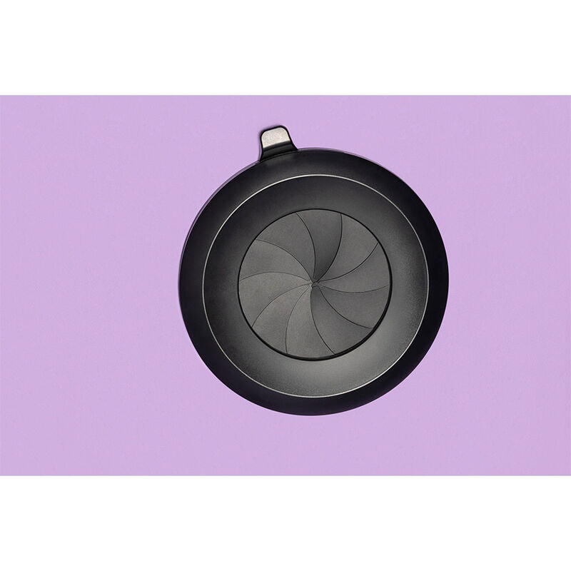 Gros plan sur le dispositif de ventilation circulaire noir integre a la paroi violette de la cabine Secret Dome, grille a pales visible