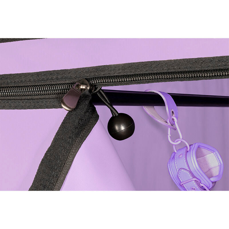 Detail d'un crochet a boule et d'une menotte de maintien lilas suspendus pres de la fermeture eclair d'angle de la cabine Secret Dome violette