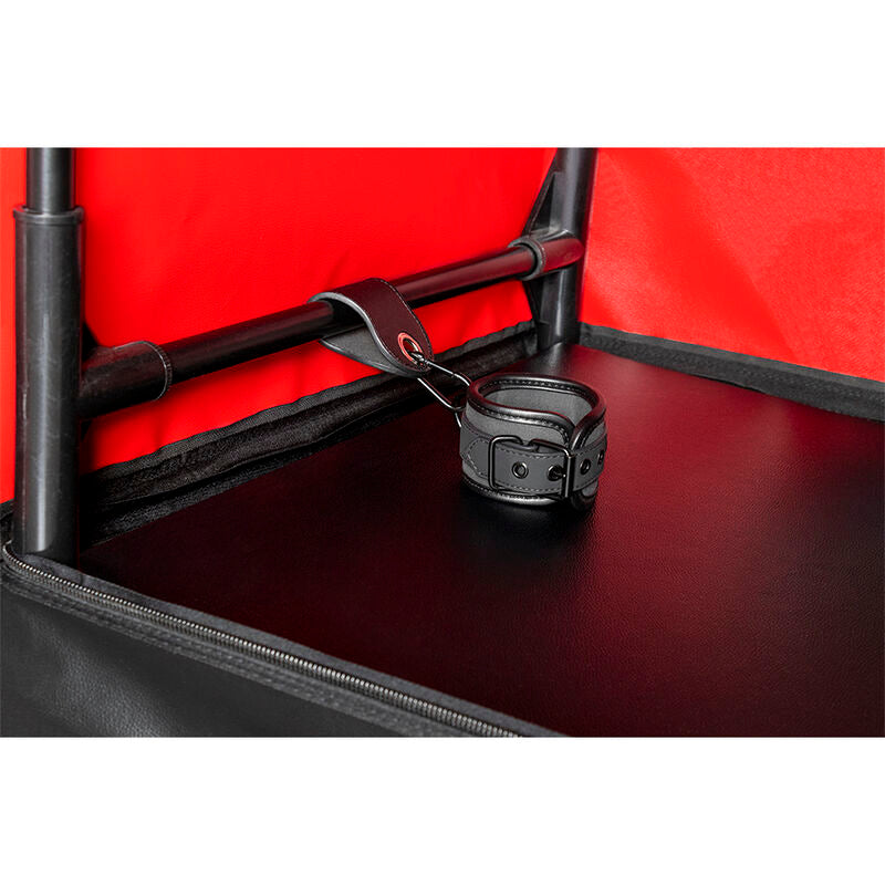 Cabine de jeu noir et rouge avec pinces et menottes — détail texture surface