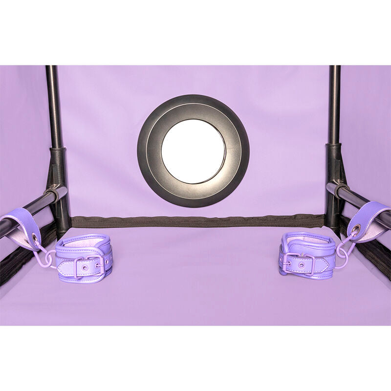 Vue interieure de la cabine Secret Dome violette montrant un orifice circulaire cercle et deux menottes de maintien lilas fixees a l'armature noire