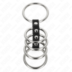 Cage penienne a anneaux d'acier superposes sur sangle cuir a pressions, accessoire cockring etage BDSM masculin presente seul