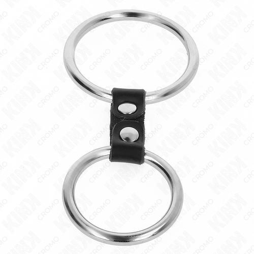 Double anneau pénien en métal brillant relié par une bande de cuir noir à rivets, présenté seul sur fond blanc, cockring de contrôle pour prolonger l'érection.
