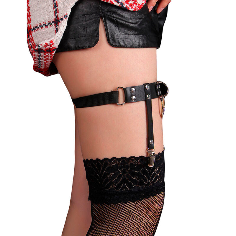 Vue laterale du harnais de cuisse en cuir noir Subblime sur jambe nue, anneau central et bas dentelle resille, accessoire jarretiere fetichiste taille unique.