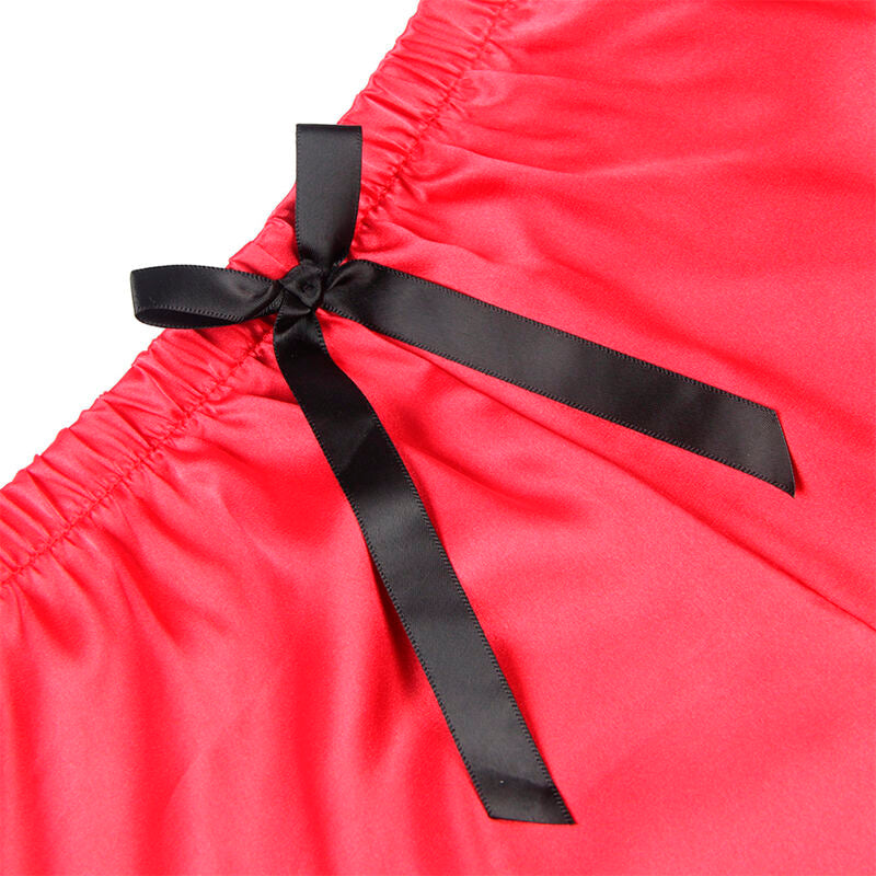 Gros plan sur le noeud satin noir et le tissu corail du short Subblime, detail textile brillant de la parure deux pieces sur fond contraste.