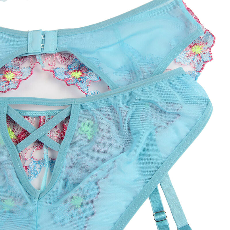 Detail a plat de la culotte turquoise Subblime a broderie florale, entrejambe ouvert et lacets croises, maille fleurie rose et vive presentee sur un fond blanc.