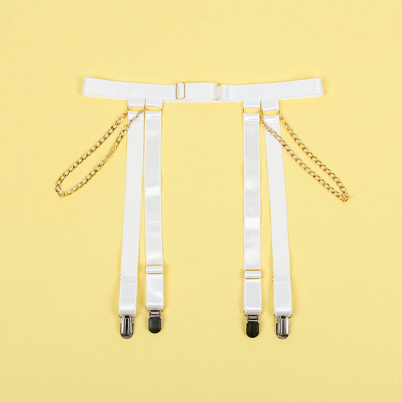 Porte-jarretelles blanc a chaines dorees et pinces metalliques presente a plat sur fond jaune, accessoire detachable du body Subblime.