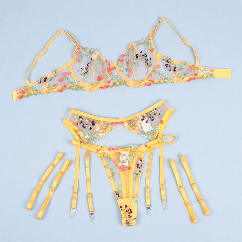 Parure lingerie florale jaune Subblime photographiee a plat sur fond bleu : soutien-gorge brode, string et porte-jarretelles a sangles, vue d'ensemble detaillee des trois pieces.