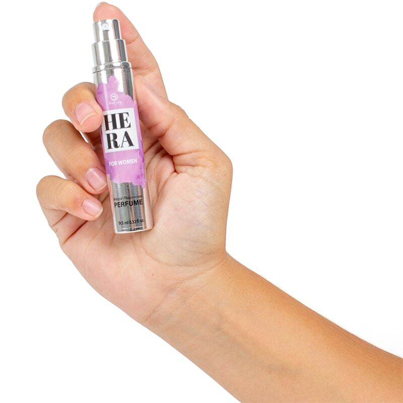 Flacon stylo Hera For Women aux pheromones tenu en main, parfum feminin nomade Secret Play, format compact a deposer sur les points de pulsation.