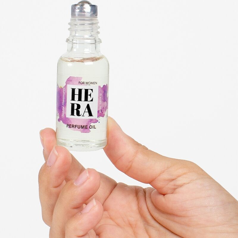 Flacon roll-on a bille Hera For Women aux pheromones tenu entre les doigts, huile de parfum feminine 20 ml Secret Play a appliquer sur les zones de pulsation.