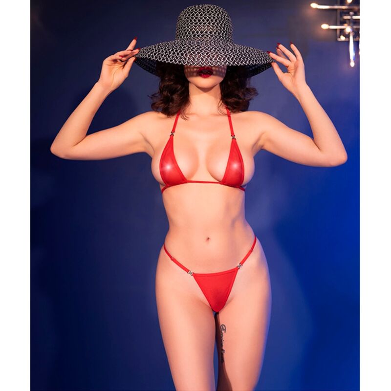 Modèle de face mains au chapeau en micro-bikini rouge brillant Chilirose. Bustier triangle et string fin échancré, ambiance pin-up sensuelle.
